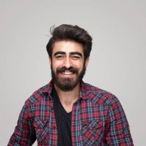 Portrait of smiling handsome man looking at camera over isolated gray background